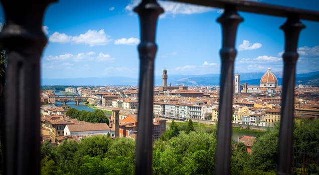 Florence panoramic view with Cathedral Santa Maria del Fiore, Pallazo Vecchio and Ponte Vecchio seen trough a fence, Italy