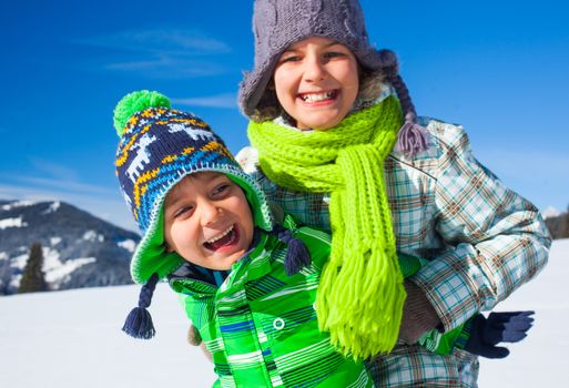 Two happy kids playing winter on the snow in Alps