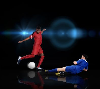 Football players tackling for the ball on black background with lights