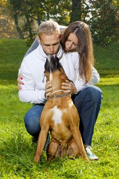 Happy Young Couple Playing with their Dog in the Park.