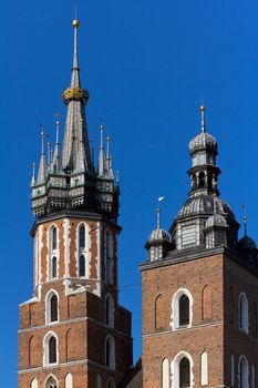 two towers of St. Mary's Basilica on main  market sguare  in cracow in poland on blue sky background