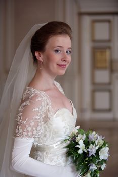 The beautiful bride with a bouquet in an interior