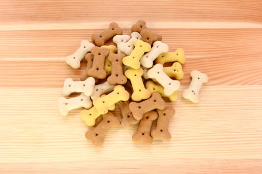 Heap of dried dog biscuits on a wood grain background