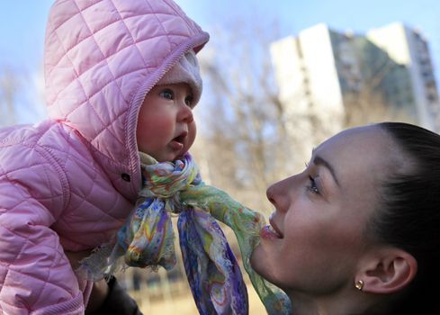 Happy mom and child girl hugging on nature. The concept of childhood and family. Beautiful Mother and her baby outdoors