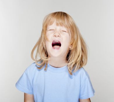 portrait of a boy with long blond hair crying - isolated on white