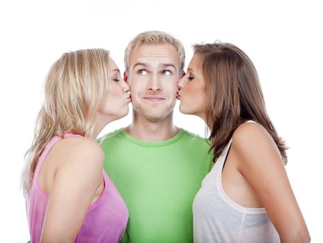 two young women kissing handsome man standing between them - isolated on white