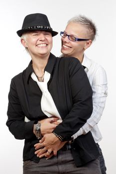 two lesbian woman with punk hairstyle embracing, smiling - isolated om white