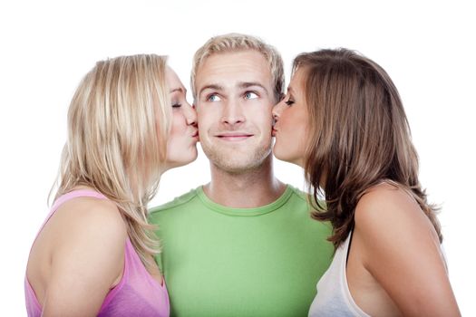 two young women kissing handsome man standing between them - isolated on white