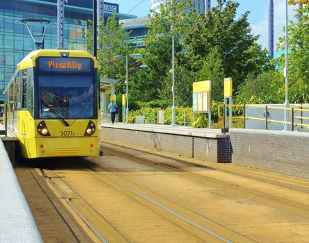 An image of a yellow Tram leaving Media City station at Salford Quays, UK.
