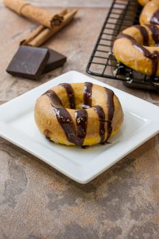 Pumpkin doughnuts with spiced glaze and choclate drizzle over the top.