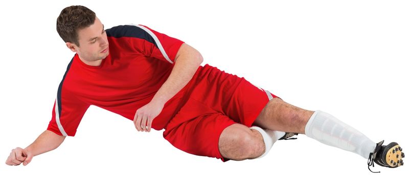 Football player in red kicking on white background