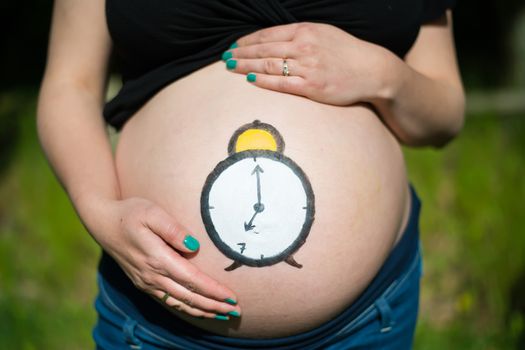 Pregnant woman with clock painted on her belly