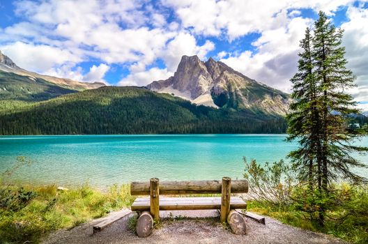 Scenic view of mountain lake and wooden bench, Emerald Lake, Banff, Canada