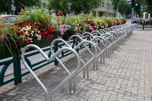 A herat shaped bike parking area with flowers nearby
