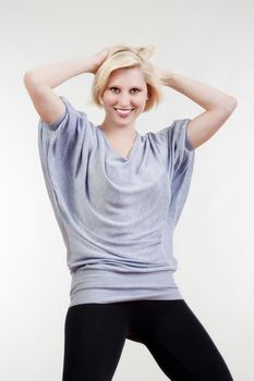 blond girl in oversized gray shirt looking smiling - isolated on white