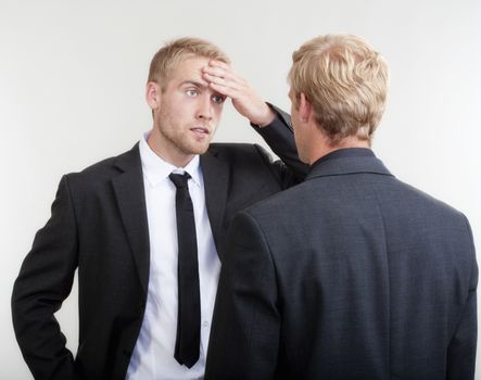 two you businessmen standing, discussing, arguing - isolated on light gray