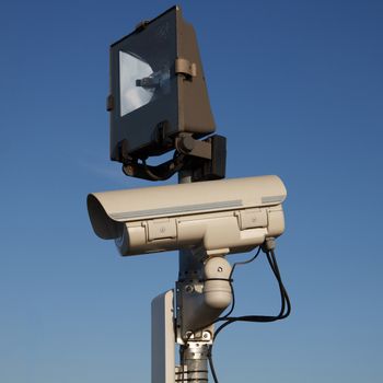 A gray security camera with a black light source