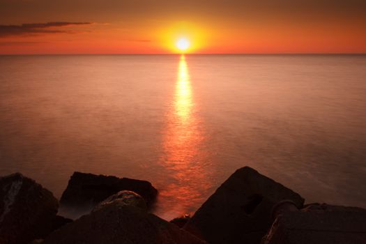 A beautiful sunset sight by the sea with blocks of stone