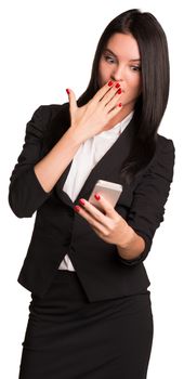 Beautiful businesswomen in suit stares at the phone in his hand. Isolated on white background