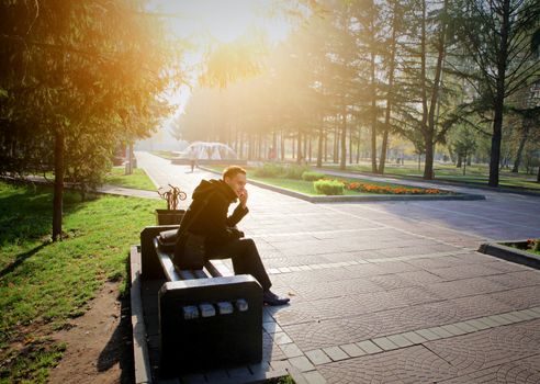 Toned photo of Young Man with Mobile Phone at the Autumn Park