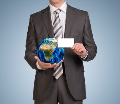 Businessman in suit hold empty card and Earth. Elements of this image are furnished by NASA