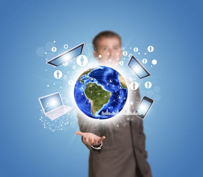 Businessman in suit hold Earth with electronics, graphs and network. Elements of this image are furnished by NASA