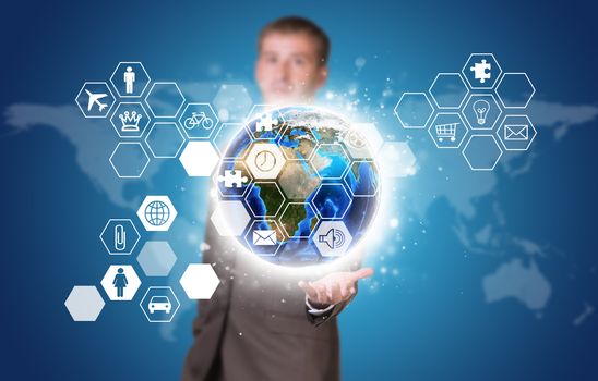 Businessman in suit hold Earth and hexagons with icons. Elements of this image are furnished by NASA