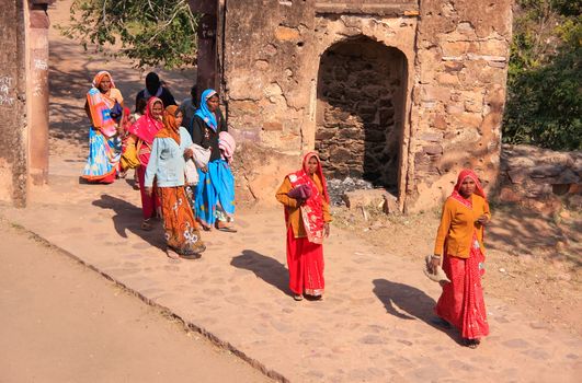 Indian women in colorful saris walking trhough the gate at Ranthambore Fort, Rajasthan, India