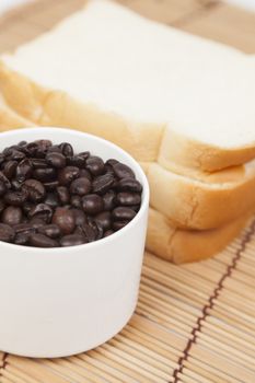 Bread plate and cup with coffee beans.on table wooden pack-shot in studio.