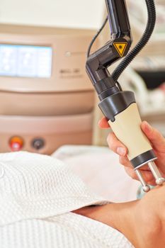 Woman getting laser face treatment in medical center, skin rejuvenation