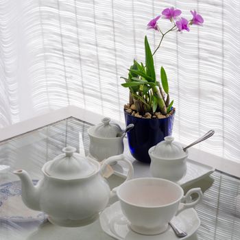 Ceramic utensils on table with flower decoration in restaurant