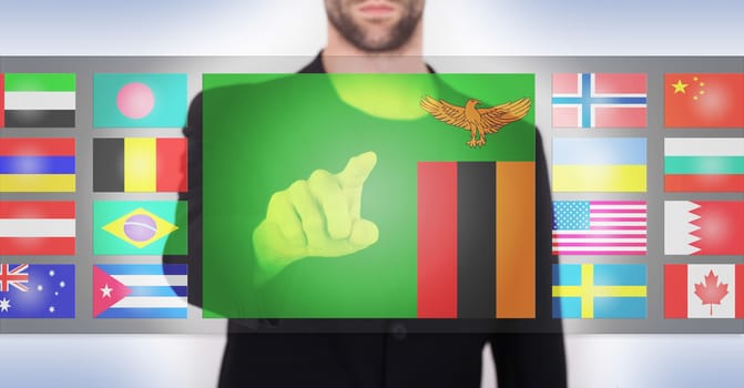 Hand pushing on a touch screen interface, choosing language or country, Zambia