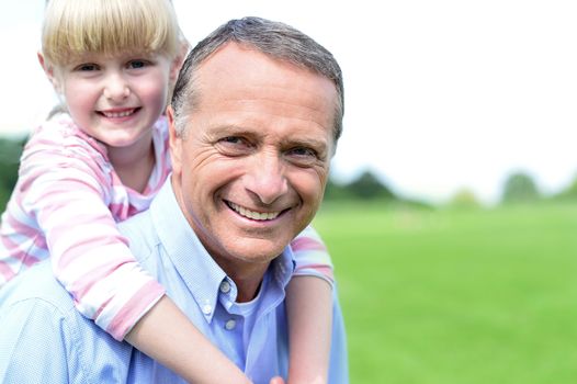 Smiling father piggybacking his daughter