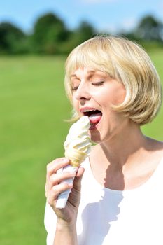 Happy woman eating ice cream at outdoors