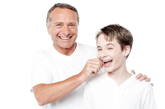Cheerful father and son posing with positive smile