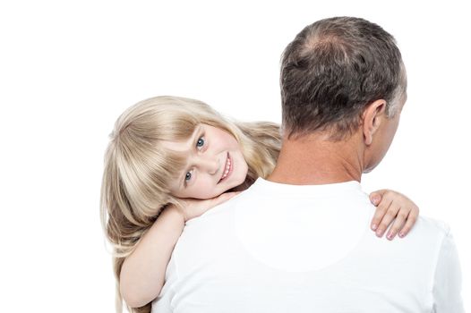 Smiling little girl resting on her father's shoulder