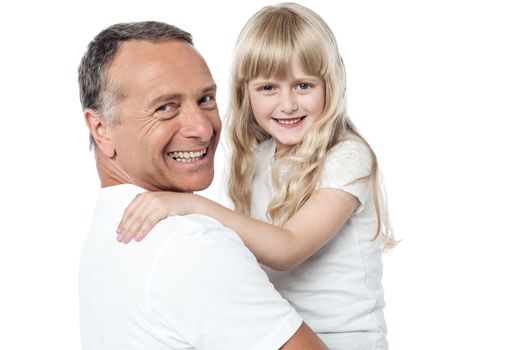 Smiling father holds the little daughter in his arms