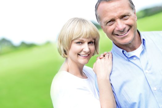 Happy middle aged couple posing together at outdoors