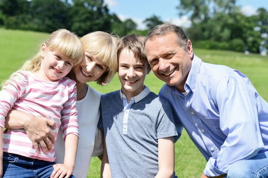 Happy family posing with two children at outdoors