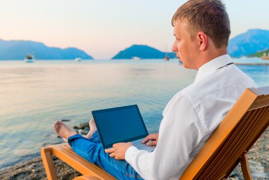 man in office clothes working on the beach