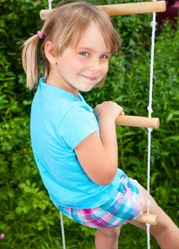 Portrait of cute little girl playing at monkey bars