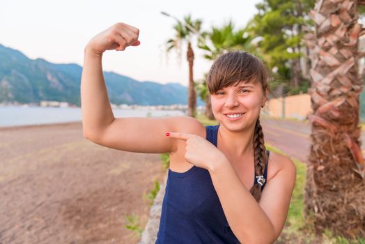 female athlete smiling and showing his biceps