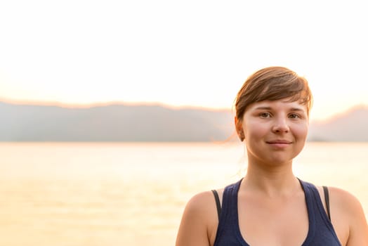 Morning portrait of a woman on a background of sea and mountains