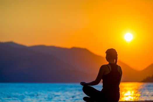 athlete on the background of mountains and rising sun relaxes