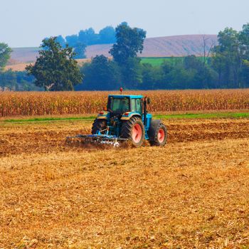 Tractor working on a field, square image