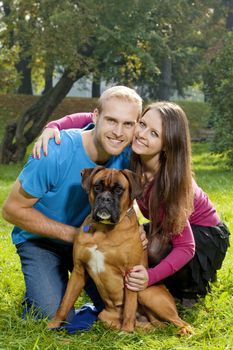 Portrait of a Happy Young Couple with their Dog in the Park.