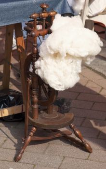 Wooden spinning wheel for weaving, on the ground