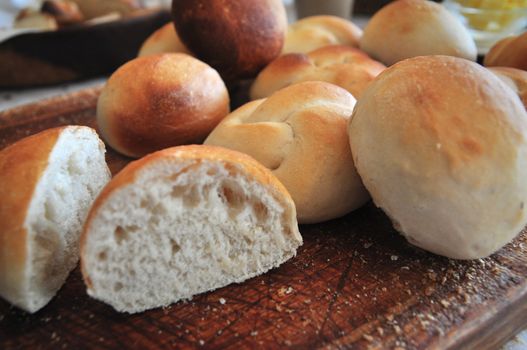 Freshly baked white buns on a cutting board, laid out for a breakfast table in the hospitality industry or home baking industry.