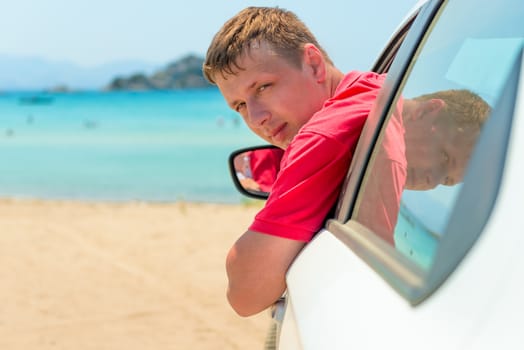 a man in a car near the sea