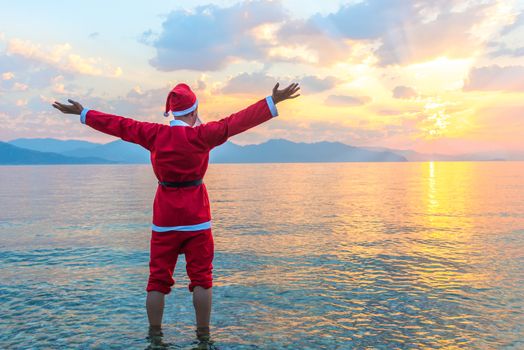 Santa Claus standing barefoot in the sea